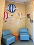 Waiting room with hot air balloon and kite decorations on the wall.